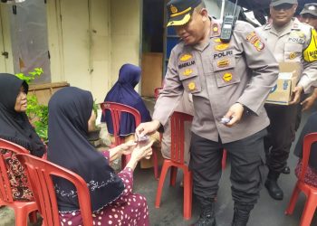 Kapolsek Johar Baru Memberikan Air Mineral Kepada Warga Menunggu Giliran Menerima Bansos