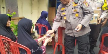 Kapolsek Johar Baru Memberikan Air Mineral Kepada Warga Menunggu Giliran Menerima Bansos